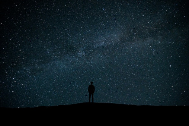 El hombre de pie sobre el fondo de estrellas