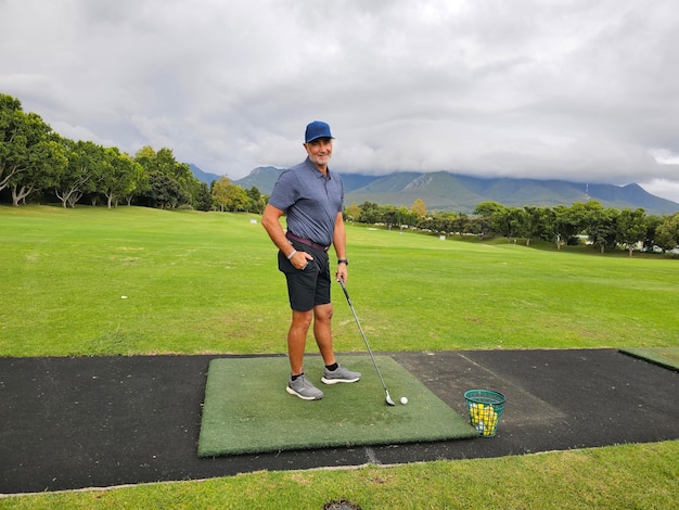 Hombre de pie en el verde poniendo una pelota de golf