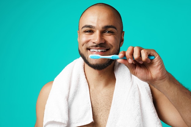 Hombre de piel oscura alegre cepillándose los dientes