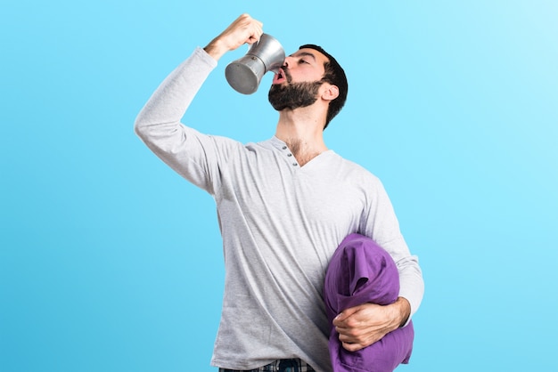 Hombre en pijama con una cafetera sobre fondo de colores