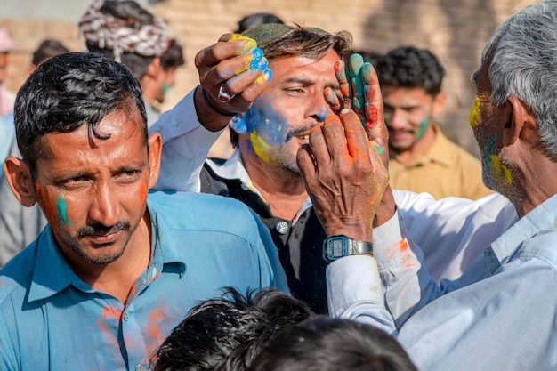 Foto un hombre se pinta la cara con polvos de colores.