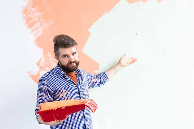 Hombre pintando la pared interior de la casa nueva