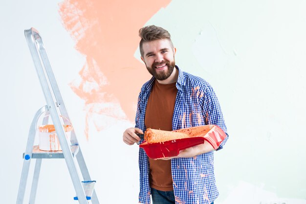 Hombre pintando la pared interior de la casa