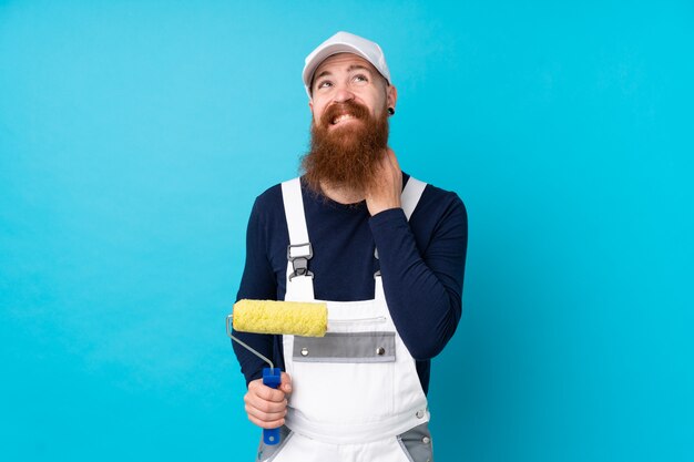 Hombre pintor con barba larga sobre pared azul aislado pensando una idea