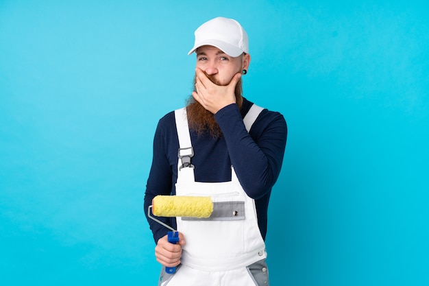 Hombre pintor con barba larga sobre pared azul aislado pensando una idea