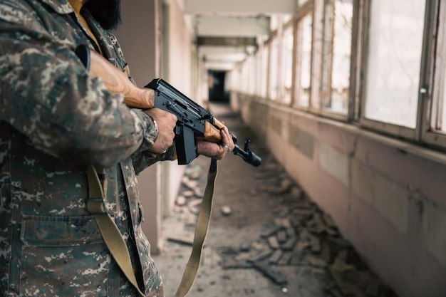 Un hombre con una pistola en un edificio destruido