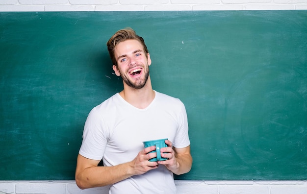 Hombre en la pizarra beber café vida universitaria maestro de escuela necesita descanso para tomar café buenos días regreso a la escuela energía inspiración para la educación estudiante hombre en el aula Tiempo para descansar Hora del desayuno