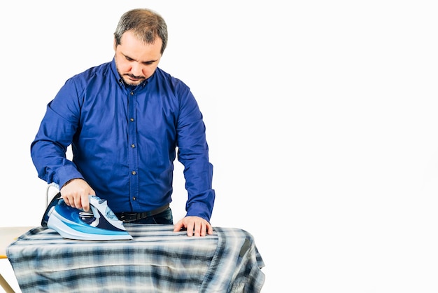 Foto hombre planchando ropa contra un fondo blanco