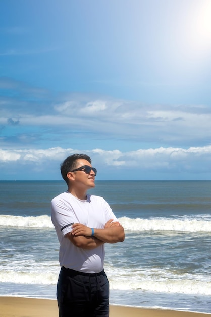 Hombre en la playa mirando felizmente al horizonte con copyspace