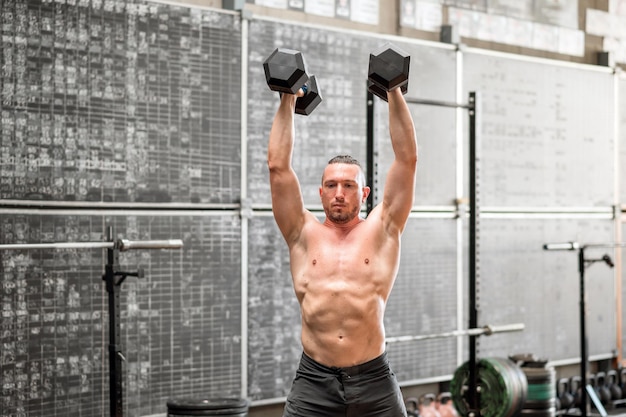 Hombre poderoso haciendo ejercicio de prensa del diablo en el gimnasio