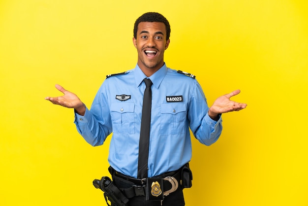 Hombre de policía afroamericano sobre fondo amarillo aislado con expresión facial conmocionada