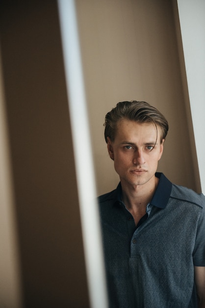 Un hombre en un polo azul posa para la publicidad de ropa masculina. Tiro para tienda de ropa masculina