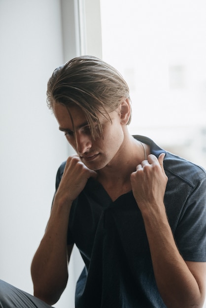 Un hombre en un polo azul posa para la publicidad de ropa masculina. tiro para tienda de ropa masculina