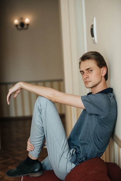 Un hombre en un polo azul posa para la publicidad de ropa masculina. Tiro para tienda de ropa masculina