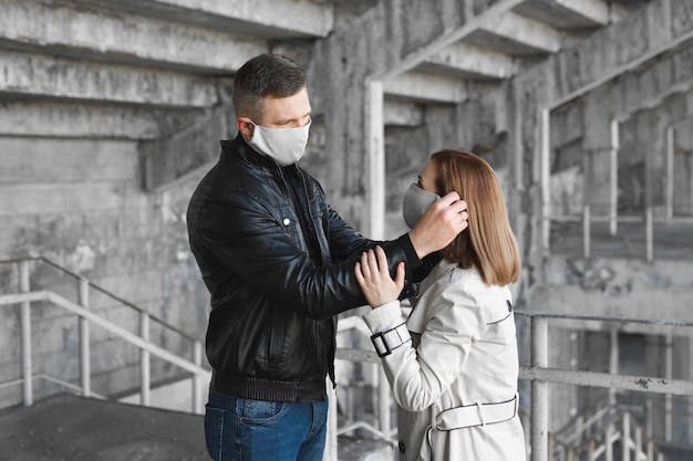 Un hombre pone una máscara protectora en la cara de una mujer. El coronavirus, Covid-19