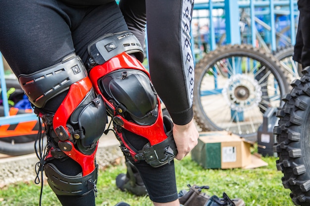 El hombre pone protección de rodillas para el deporte del motor