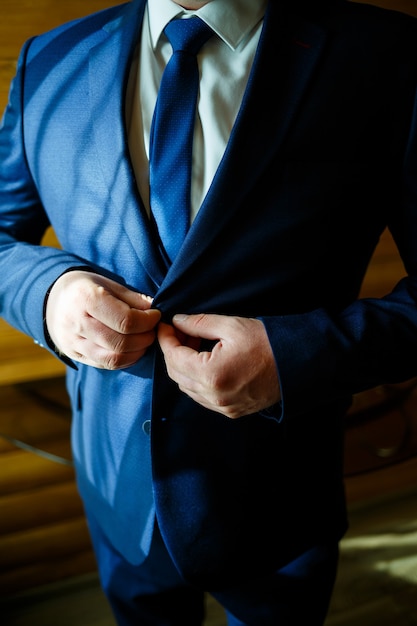 El hombre se pone un traje de boda y accesorios el día de la boda.