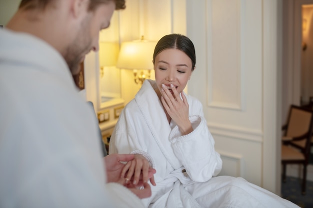 Un hombre poniendo un anillo de compromiso en el dedo de su novia