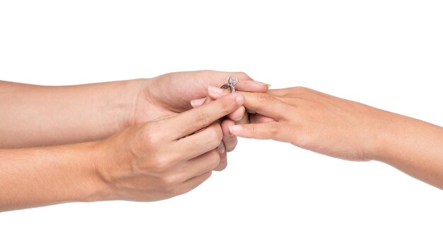 Foto hombre poniendo anillo de compromiso en la mano de la mujer aislar sobre fondo blanco.