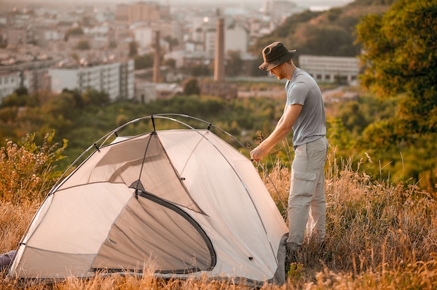 Un hombre poniendo la carpa y mirando involucrado.