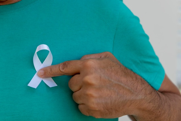 Hombre poniendo cinta blanca en su camisa. representa un programa de prevención de la salud mental. Blanco de enero.