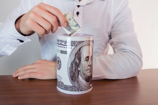 Hombre poniendo dinero en un banco de un dólar