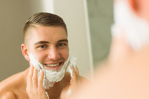 Hombre poniendo espuma de afeitar en la cara