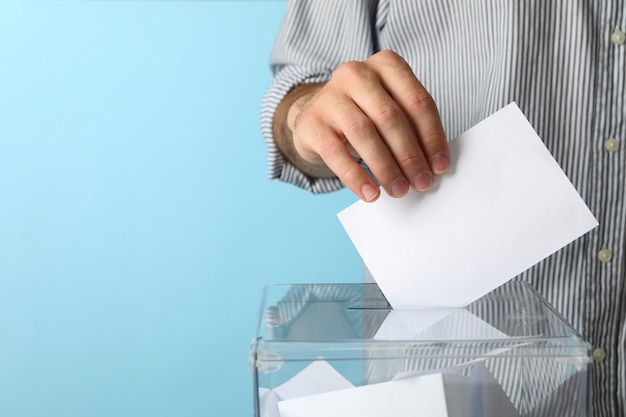 Foto hombre poniendo papeleta en urna de votación