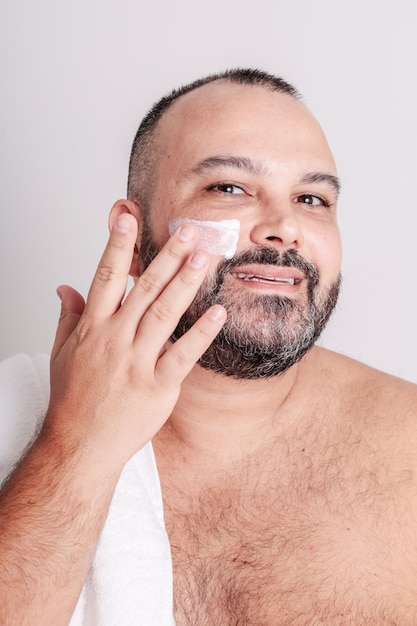 Foto hombre poniéndose crema hidratante en la cara