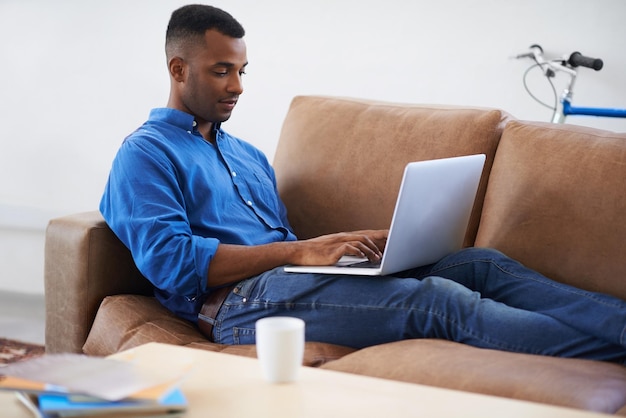 Hombre portátil y mecanografía para trabajo remoto en el hogar freelance y copywriting en la sala de estar persona masculina negra en línea y plan en tecnología o conexión para información de sitio web y investigación para el artículo