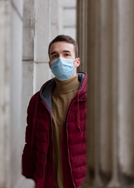 Hombre posando al aire libre con máscara médica