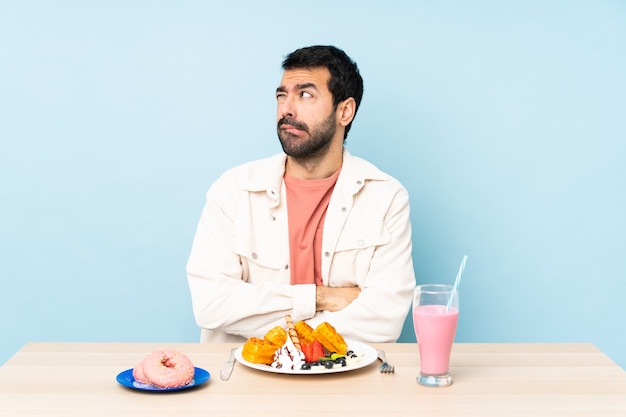 Hombre posando en una mesa con comida