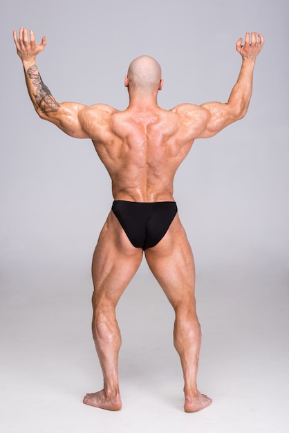 Foto el hombre está posando y muestra sus músculos.