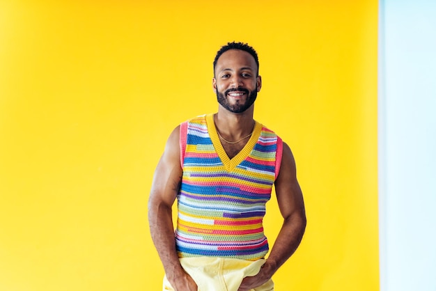 Hombre posando sobre fondos de colores en el estudio con ropa de moda