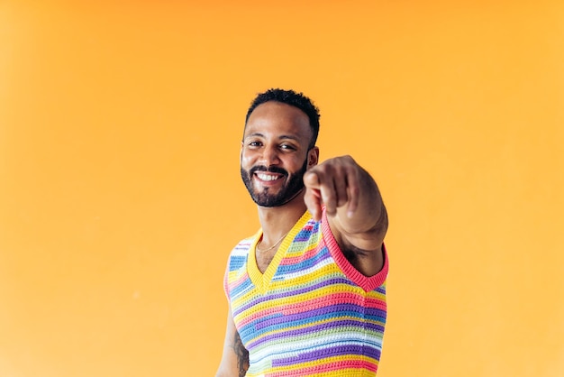 Hombre posando sobre fondos de colores en el estudio con ropa de moda