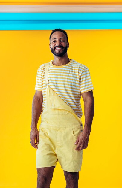 Hombre posando sobre fondos de colores en el estudio con ropa de moda