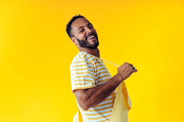 Hombre posando sobre fondos de colores en el estudio con ropa de moda