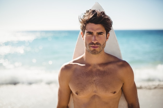 Hombre posando con tabla de surf