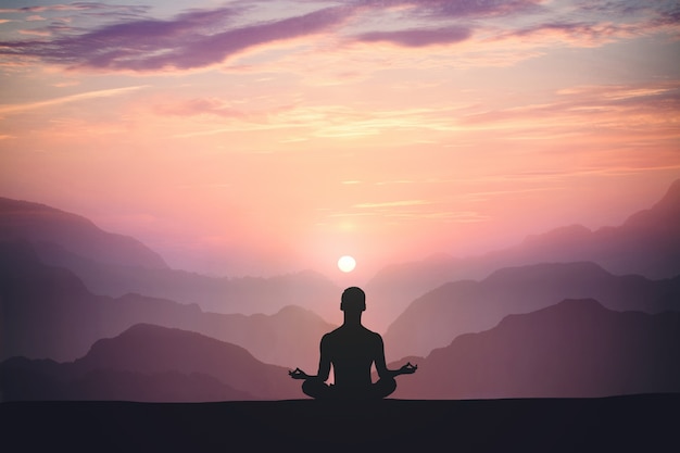 El hombre practica yoga y medita en la montaña y el atardecer.