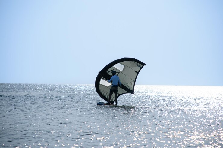 Hombre practicando kitesurf en la playa