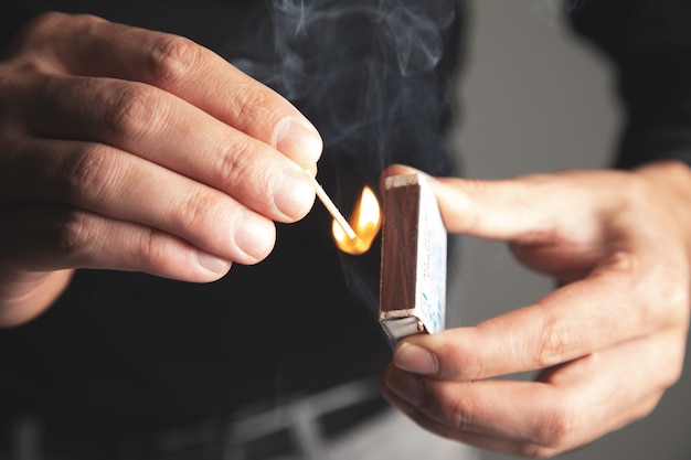 Foto un hombre prende fuego a un fósforo de madera