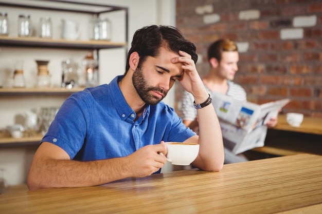 Hombre preocupado bebiendo un café