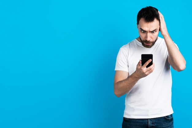 Hombre preocupado mirando el teléfono inteligente