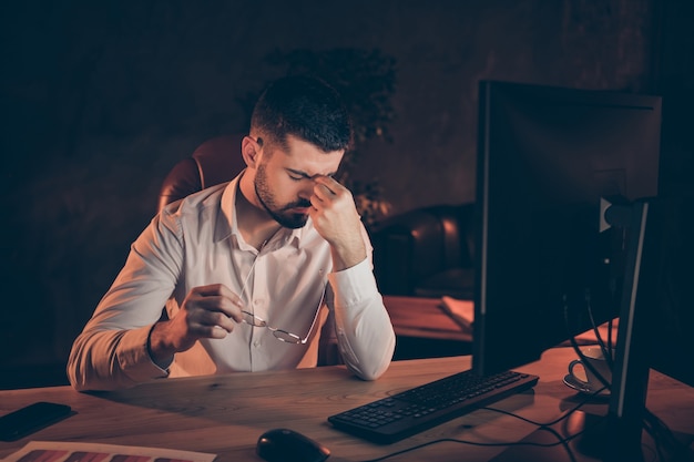 Hombre preocupado preocupado con dolor de cabeza trabajo noche computadora