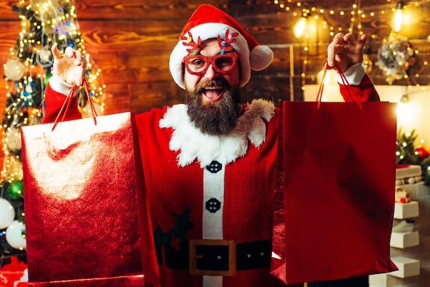 Hombre de preparación de Navidad celebrando Año Nuevo Estilismo Santa hipster con una larga barba posando en el