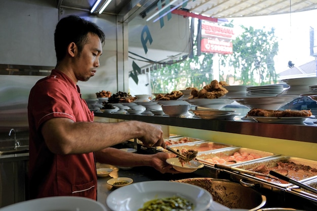 Hombre preparando comida mientras está de pie en un restaurante