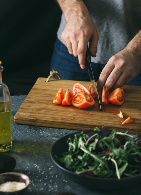 Hombre preparando ensalada de verduras