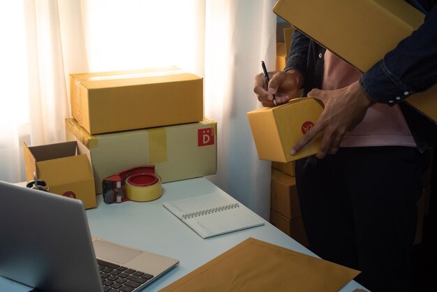 hombre preparando un paquete para la entrega en la oficina comercial de venta en línea Envío directo de comercio electrónico