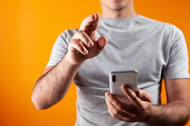 El hombre presiona la pantalla mientras sostiene el teléfono