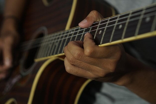 Hombre de primer plano tocando la guitarra acústica